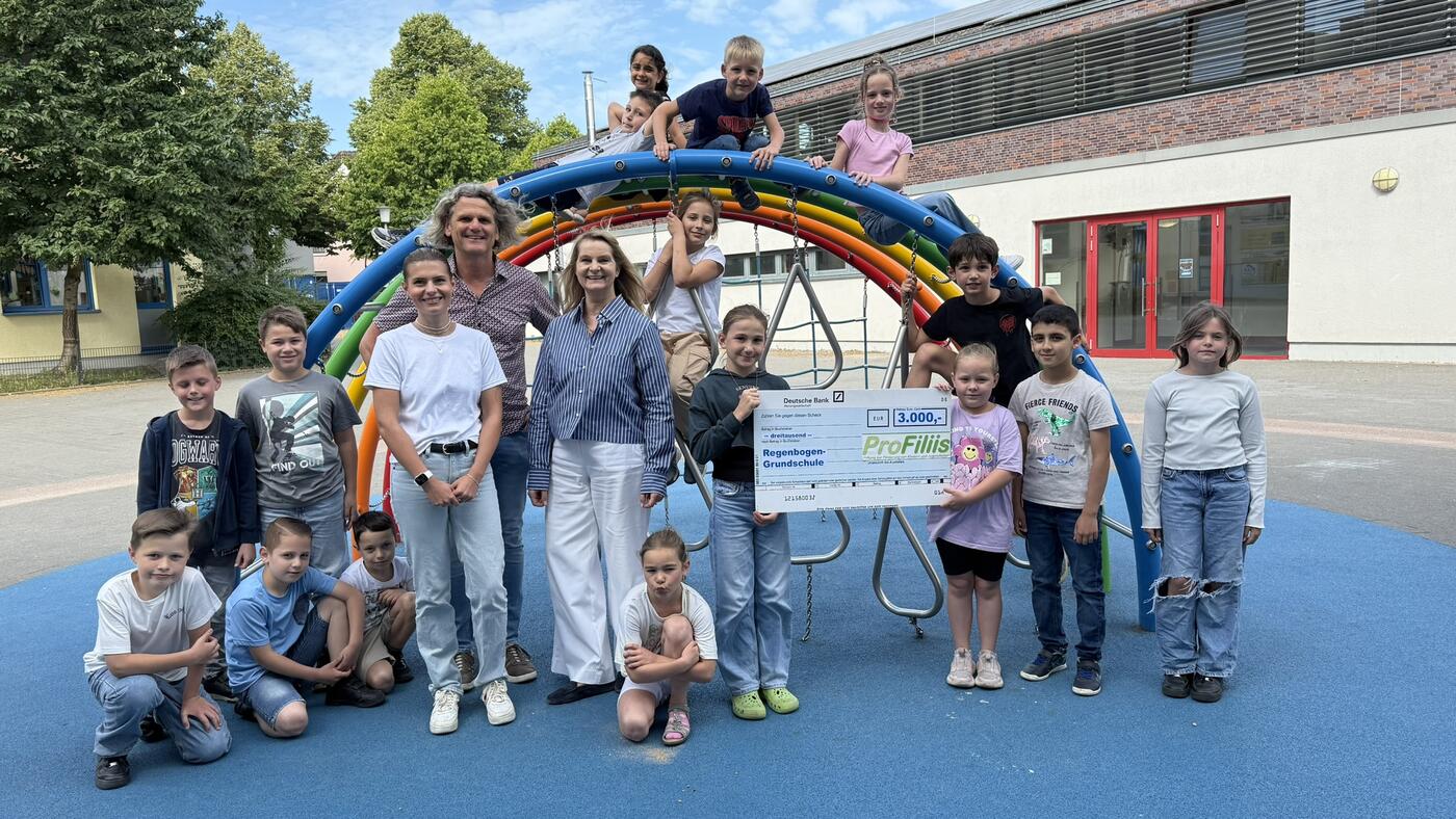 v.l.n.r.:  Svenja Felbier (Projektbetreuung ProFiliis), Thomas Schieferstein (Vorstand ProFiliis), Claudia Ohlhage (Schulleiterin Regenbogen-Grundschule) sowie Schüler:innen der Regenbogen-Grundschule. (Foto: Tolbert Iberdemaj (Regenbogen-Grundschule)) 