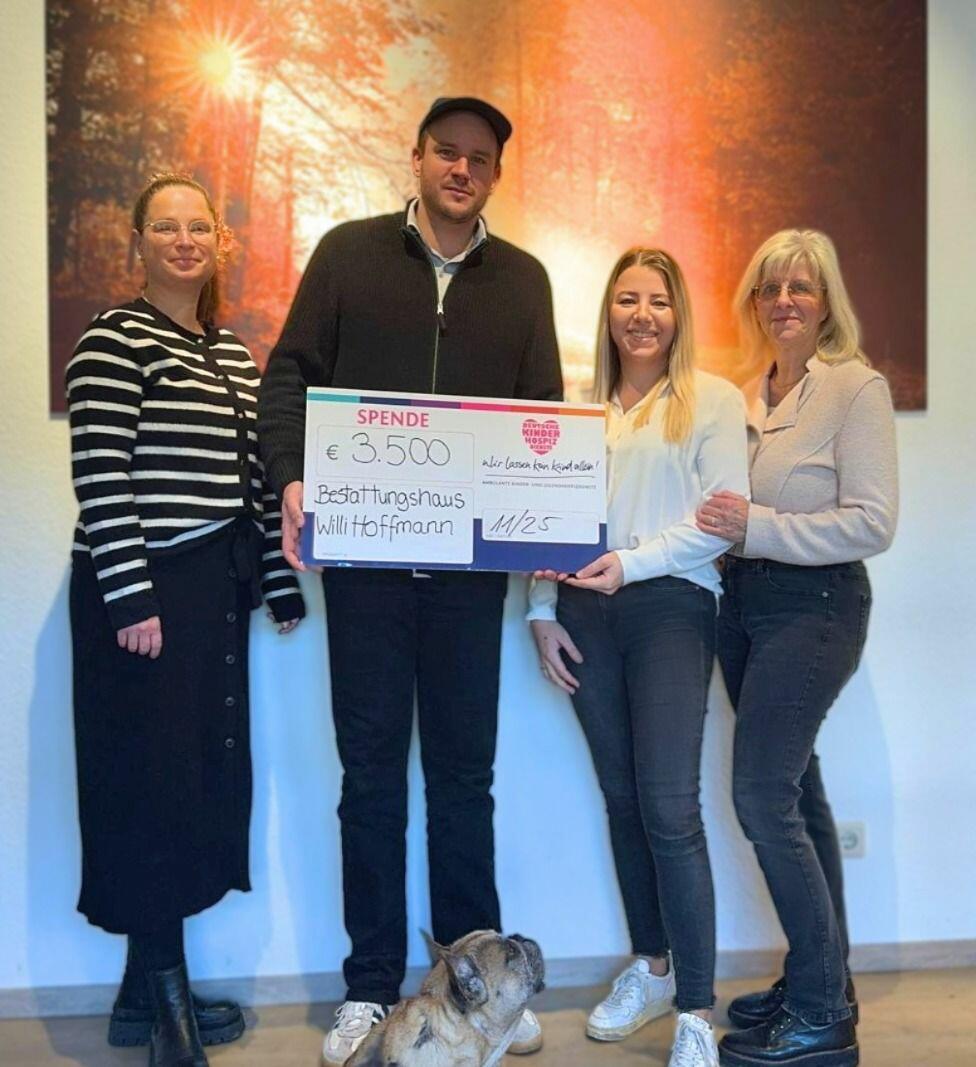 Yvonne Berger (links) sowie Christiane Preuß (2. von rechts) und Susanne Preuß (rechts) und der Seelentröster des Bestattungshauses, Hund Carlo, überreichten Fabian Reimertz aus dem  Fundraising-Team der Deutschen Kinderhospiz Diensten und Bärenbotschafter Hope jetzt den  symbolischen Spendenscheck. (Foto: Deutsche Kinderhospiz Dienste / Christine Haufe)