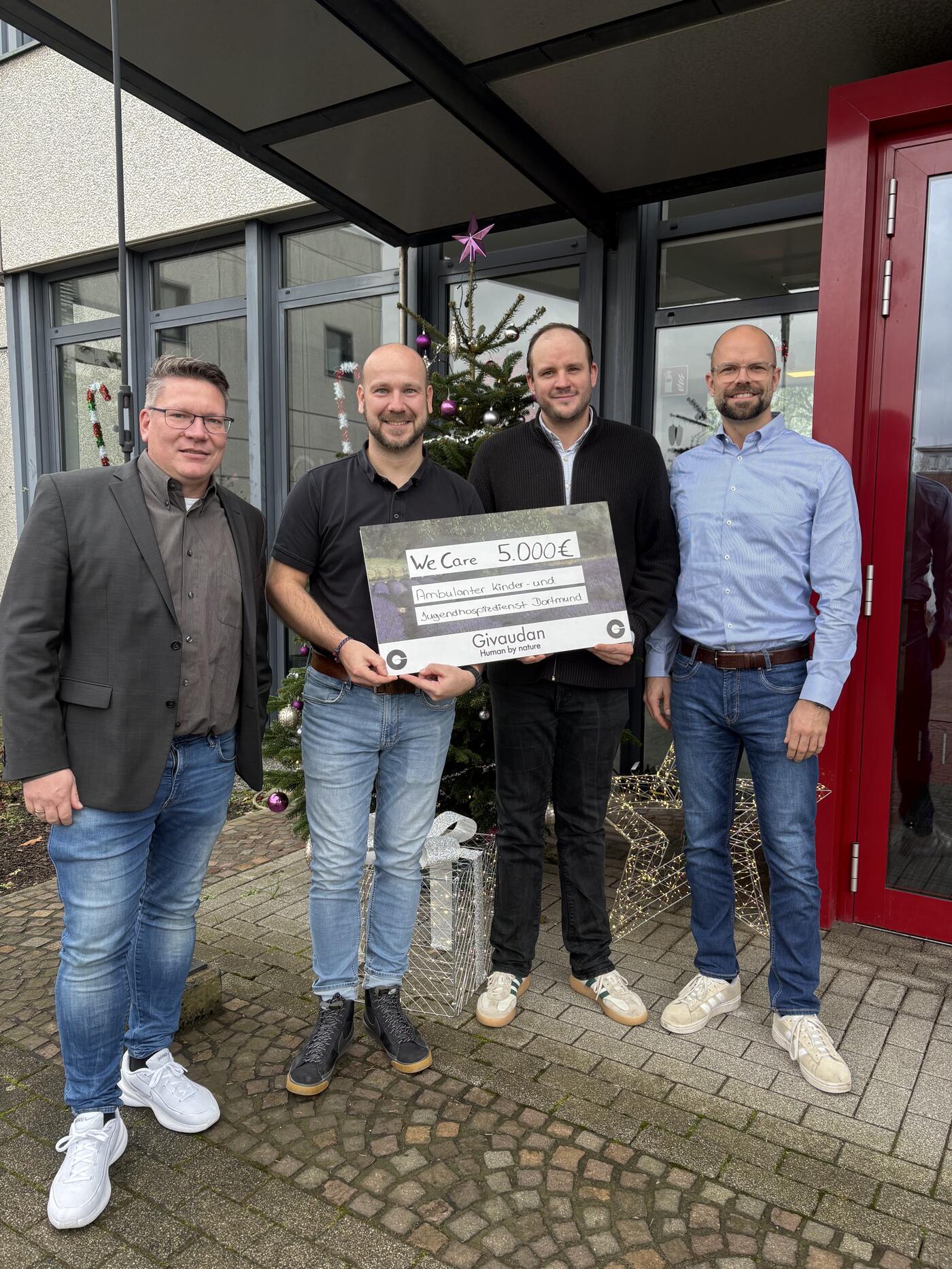 Übergabe des symbolischen Spendenschecks an Fabian Reimertz (2. von rechts) von den Deutschen Kinderhospiz Diensten durch: Geschäftsführer Stephan Nürrenberg, Mitarbeiter Marcel Koch und Sebastian Schaper als Commercial Director (von links nach rechts). (Foto: Nadine Urland / Givaudan) 