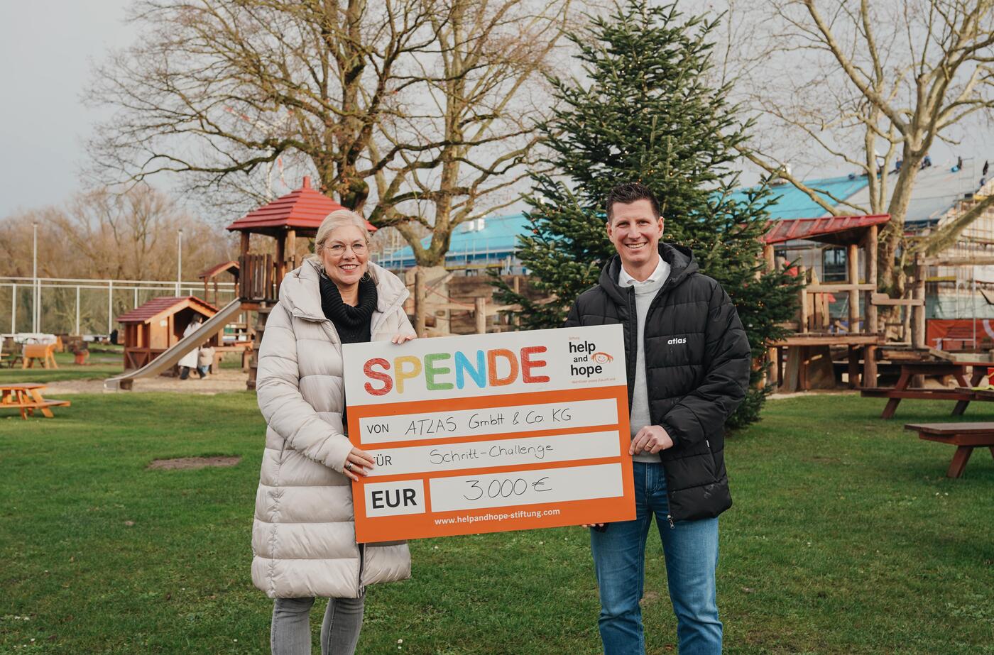 Wer andere in Bewegung bringt, kann auch viel bewegen:  ATLAS hat bei einem Messeauftritt im Rahmen einer Schritt-Challenge  Spenden gesammelt. Maximilian Finke, Head of Marketing der ATLAS GmbH  & Co. KG (rechts), überreichte nun 3.000 Euro and Sandra Heller,  Vorstandsvorsitzende der help and hope Stiftung (links). (Foto: help and hope Stiftung) 